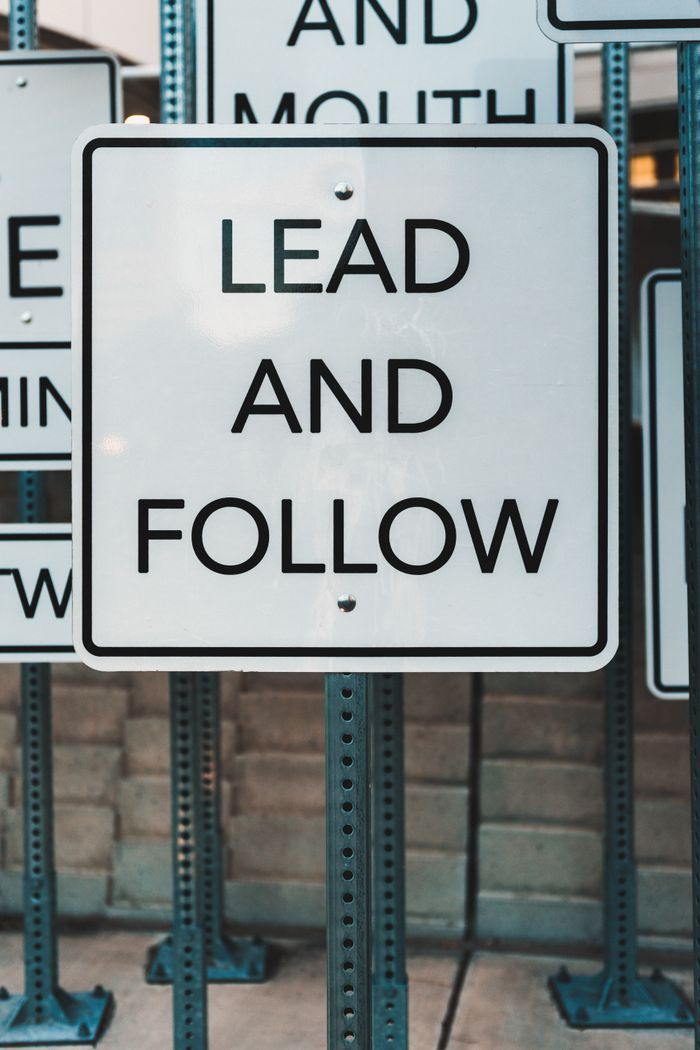 gallery-3 Photo of urban signage displaying Lead and Follow, emphasizing guidance and navigation.