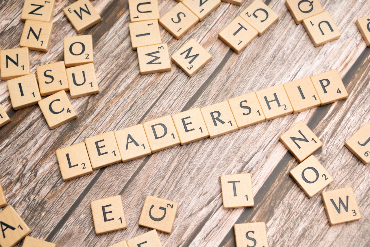 hero-img-02 Wooden letter tiles spelling LEADERSHIP on a wooden surface, symbolizing leadership qualities and skills.